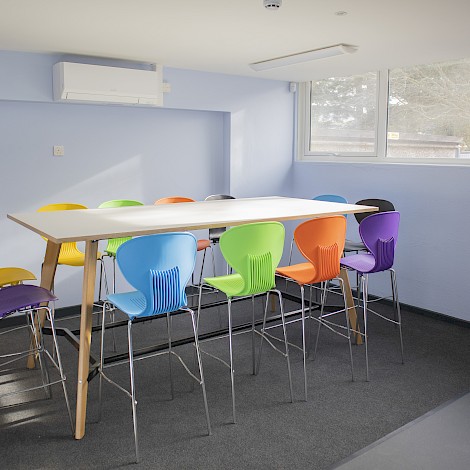 High desk with brightly coloured tall chairs for school.